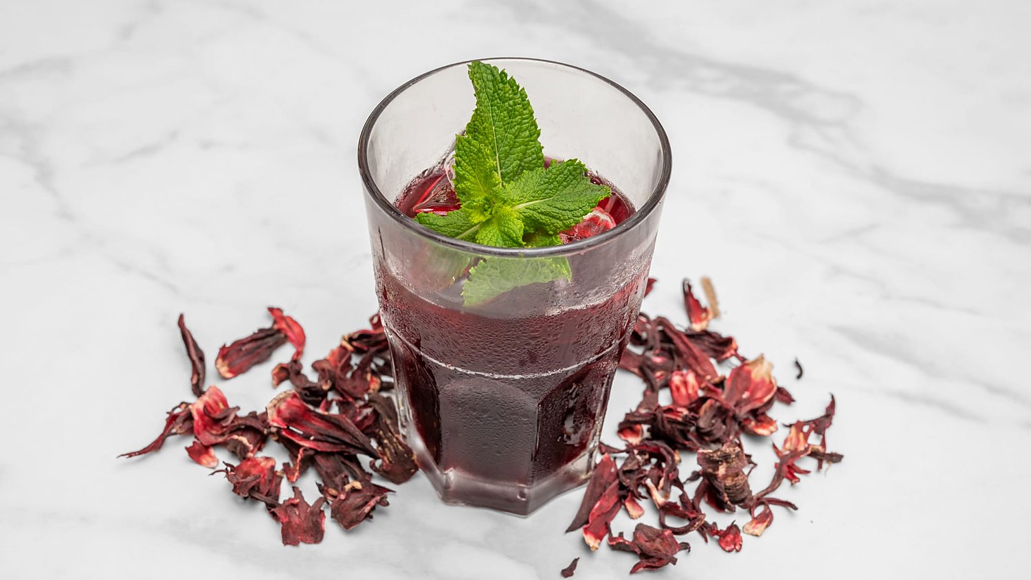 Bissap maison servi glacé, fleurs d'hibiscus et menthe fraîche