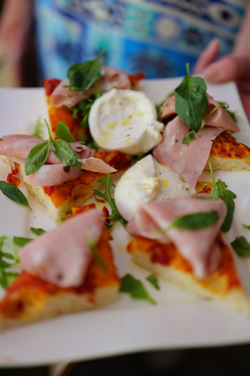 Focaccia à la mortadelle et burrata, plateau à partager tenu à bout de bras